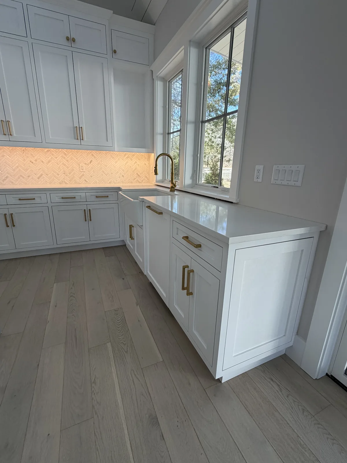 Kitchen with custom cabinetry, quartz counters and brass hardware