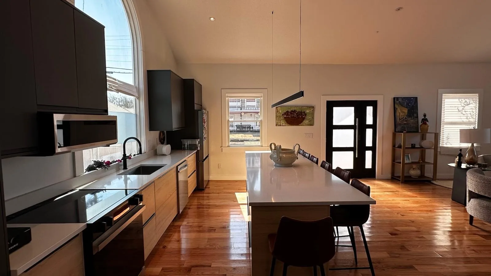 Modern kitchen with long island, dark cabinetry and hardwood floors