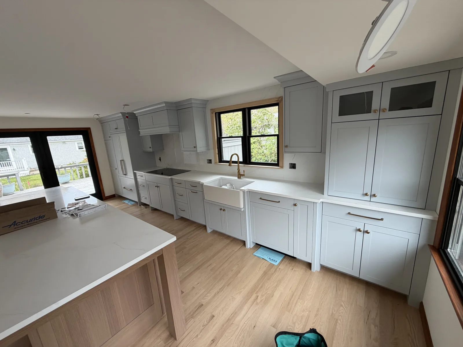Light gray kitchen with island and wide plank flooring