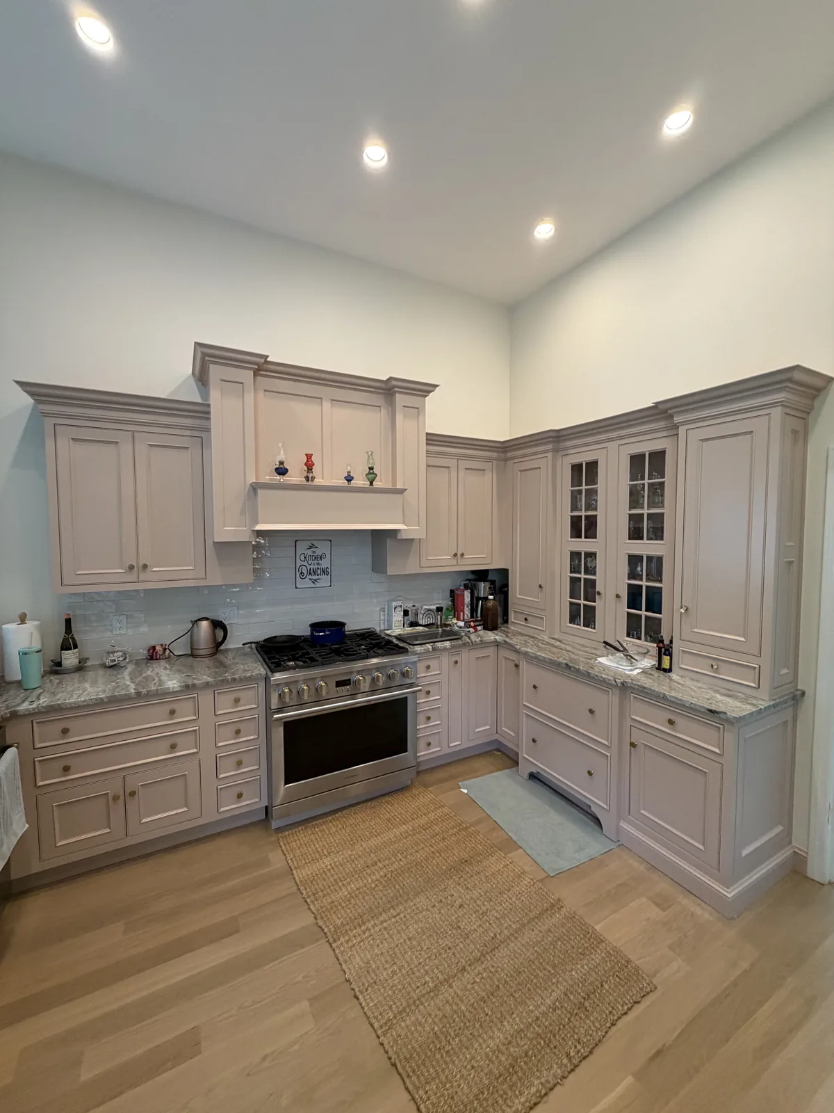 Kitchen with glass front cabinets, range and warm wood floors