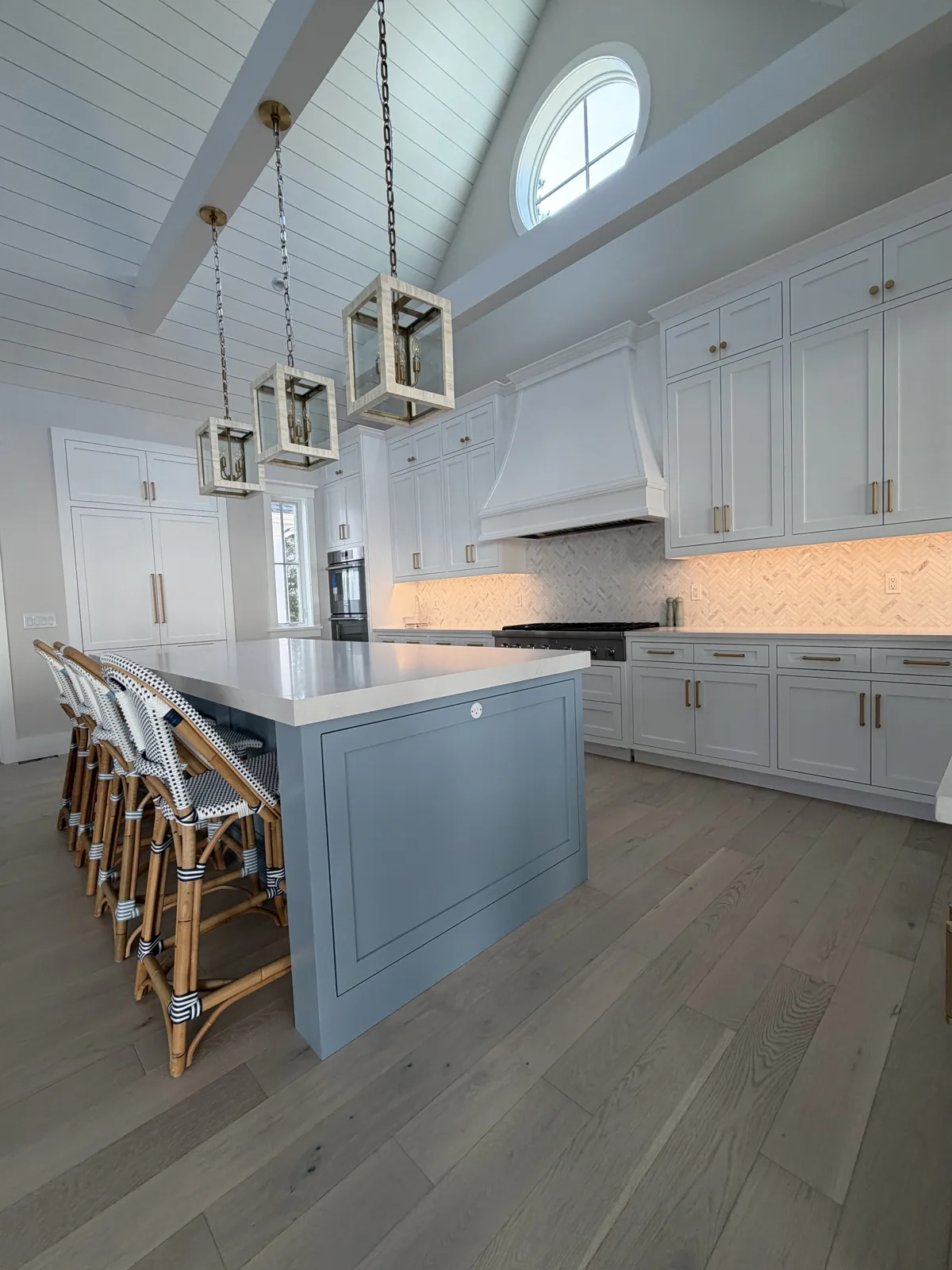 Kitchen remodel with blue island, white cabinetry and wood floors