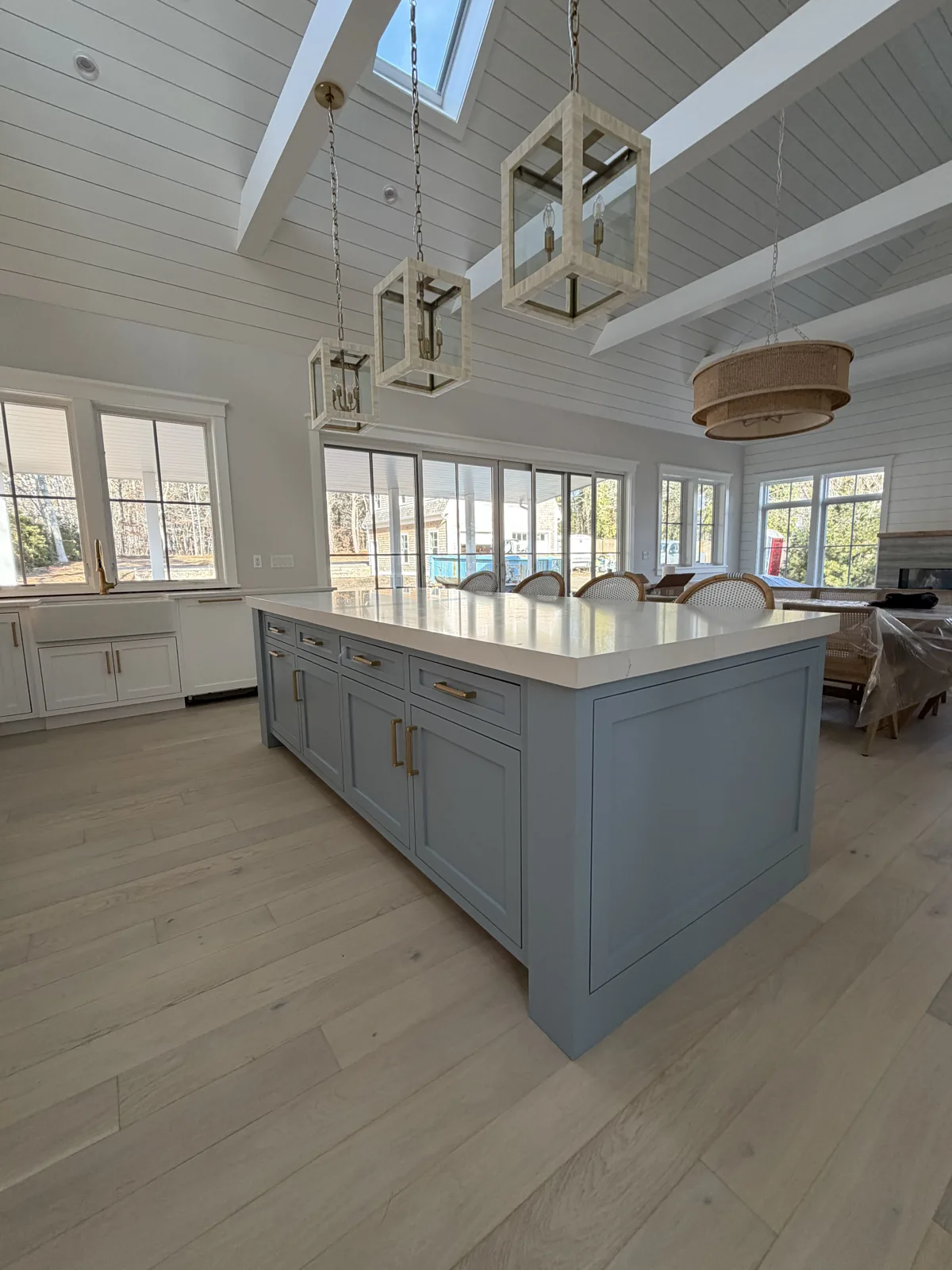 Open kitchen with blue island under a vaulted ceiling