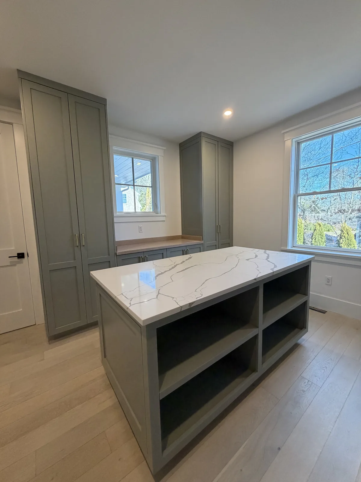 Kitchen island with open shelving and marble countertop