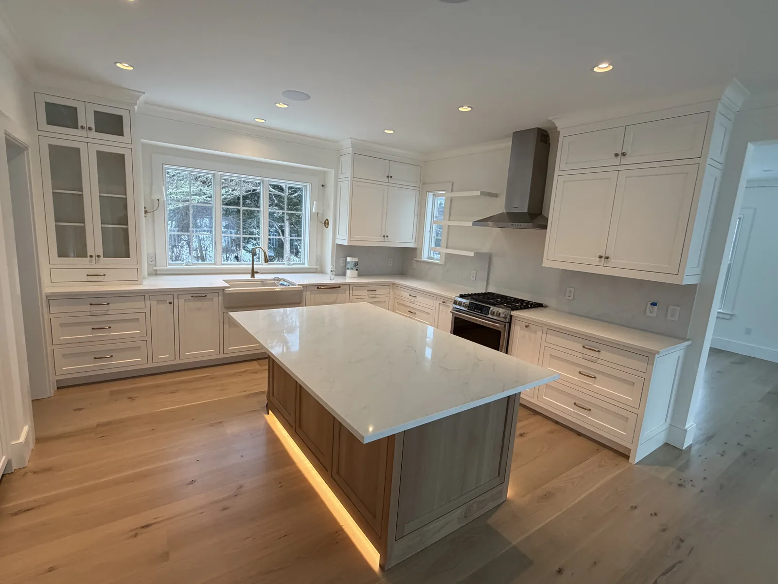 White kitchen with wood island and hardwood flooring