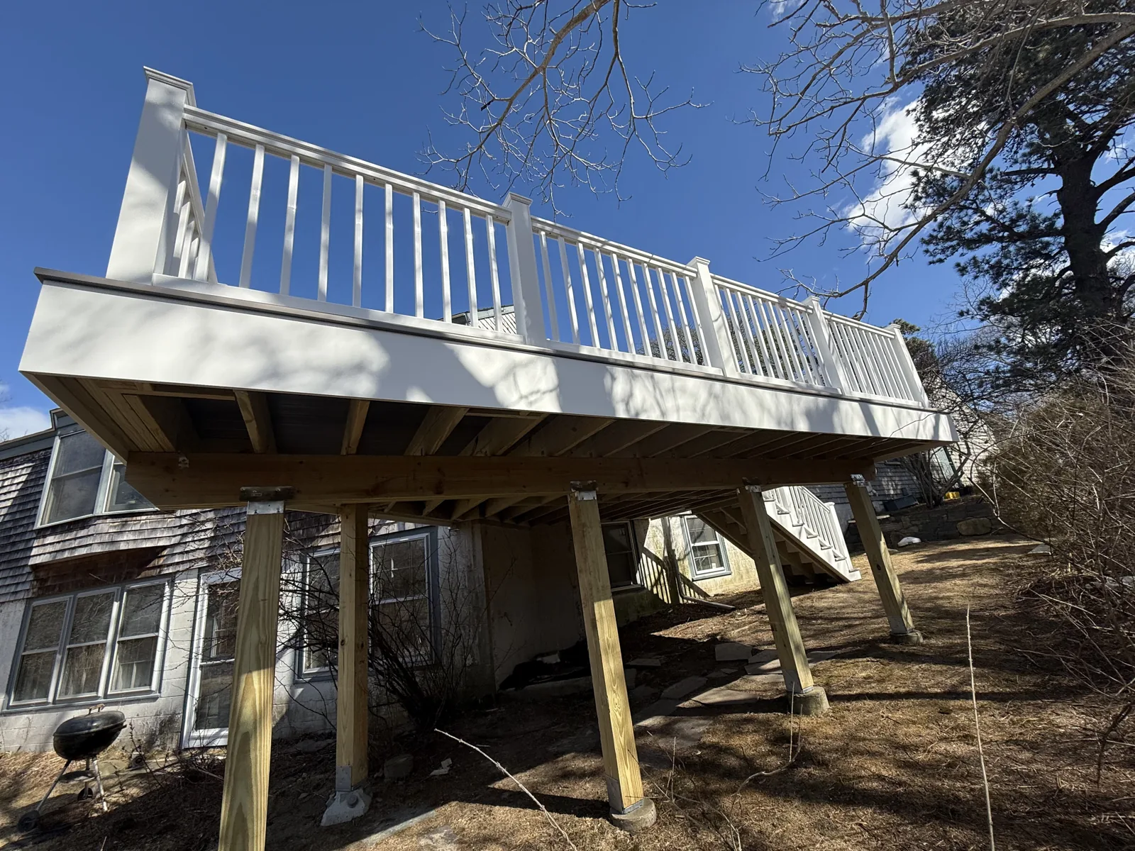 Elevated deck framing with posts and white railing