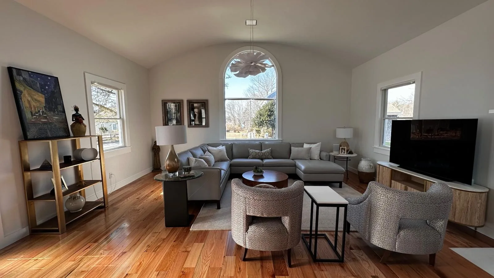 Living room with vaulted ceiling, built-in shelving and wood floors