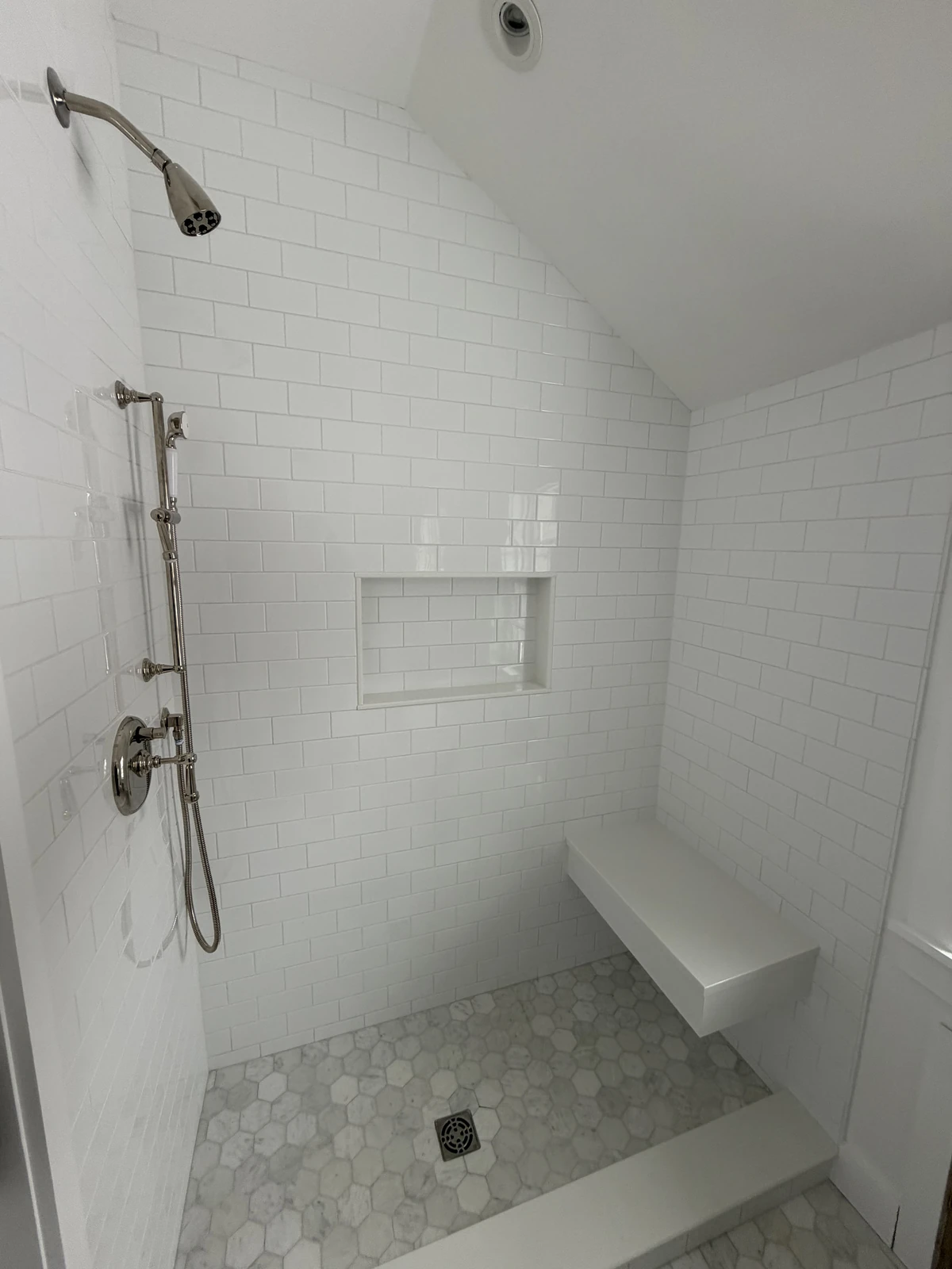 Tiled walk-in shower with a built-in bench