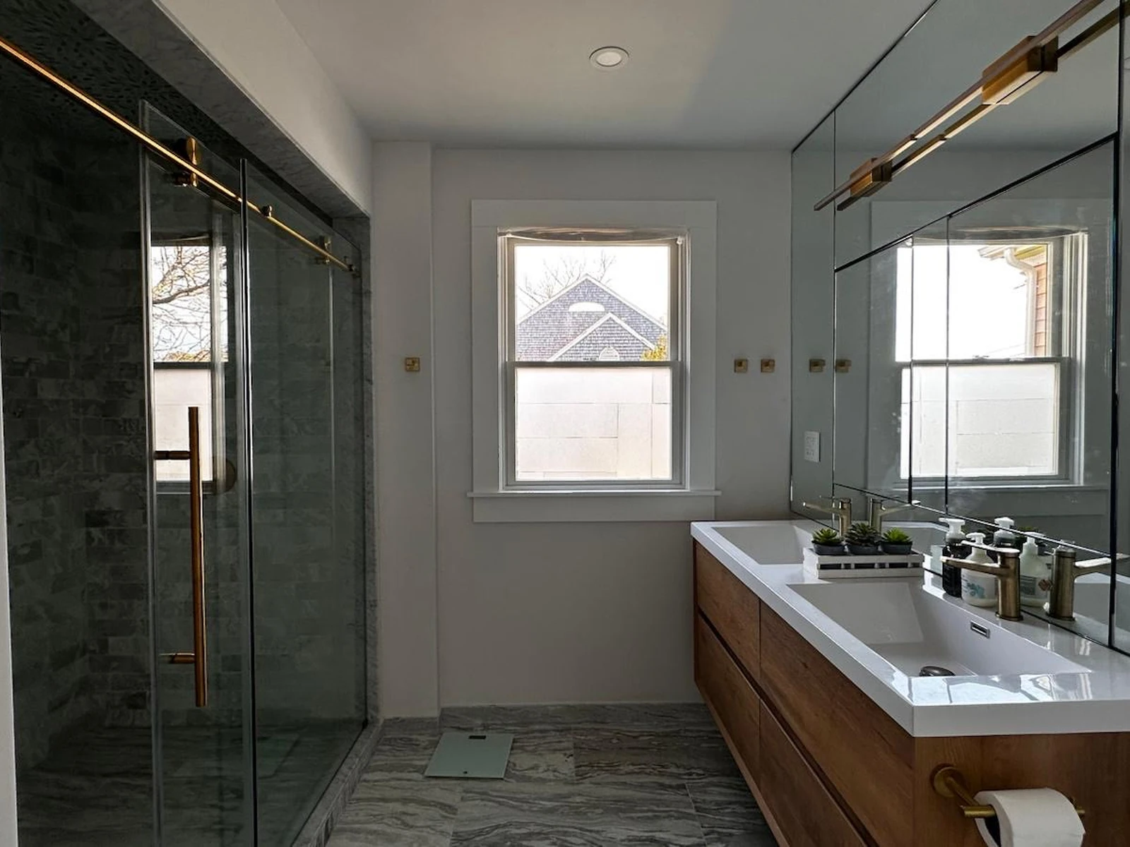 Floating wood vanity with a glass shower