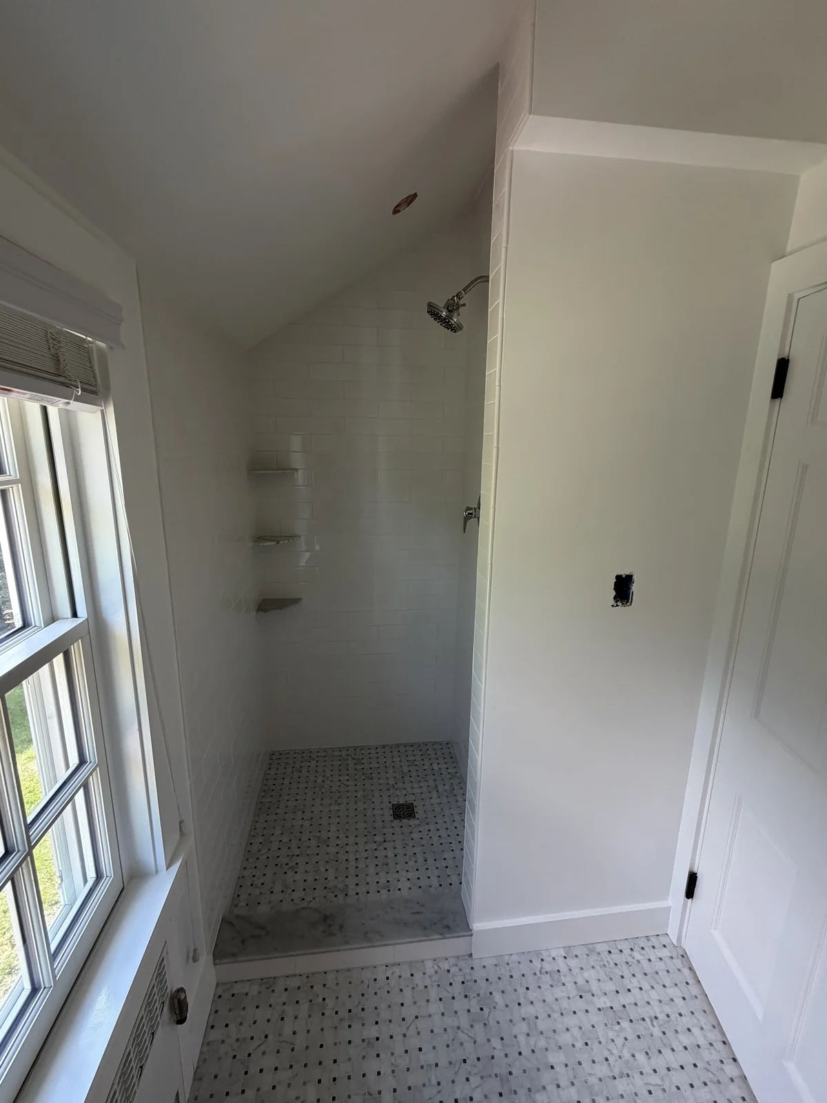The same alcove after the remodel, opened into a walk-in shower with white subway tile
